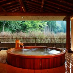 an outdoor hot tub in the middle of a wooden deck