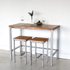 two wooden stools sitting next to a table