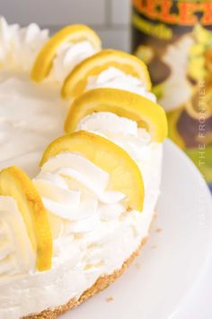 a lemon and meringue cheesecake on a white plate with a can in the background