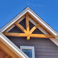 the top of a house with a wooden cross on it's roof and windows