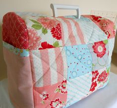 a pink and blue patchwork bag sitting on top of a white table