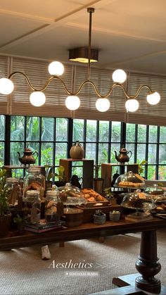 a buffet area with many different types of food on the table and lights hanging from the ceiling