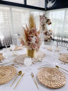 a table set with place settings and flowers