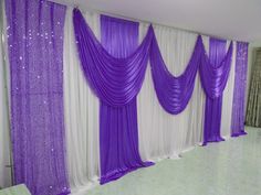 purple and white drapes are hanging in front of a wall with sequins