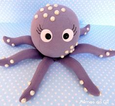 an octopus stuffed animal sitting on top of a blue and white polka dot table cloth