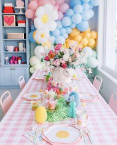 the table is set with pink, white and blue balloons in the back drop off area