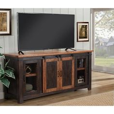 a flat screen tv sitting on top of a wooden entertainment center