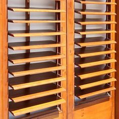 two wooden shelves with open shutters on each side