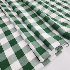 the green and white checkered fabric is folded up on top of each other,