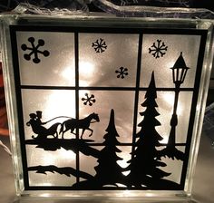 a glass block with silhouettes of christmas trees and sleigh