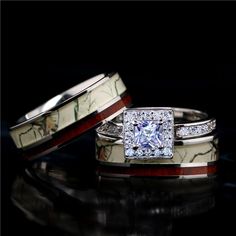 two wedding rings with white and red marble inlays on each band, set against a black background