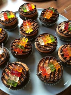 there are many cupcakes with candies on the top and chocolate icing