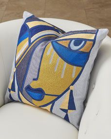 a blue and yellow pillow sitting on top of a white chair next to a wooden floor