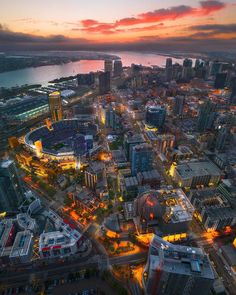 an aerial view of a city at night with the lights on and buildings lit up