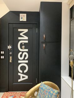 a black door with the word museum on it and a chair in front of it