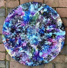 a colorful plate sitting on top of a brick wall