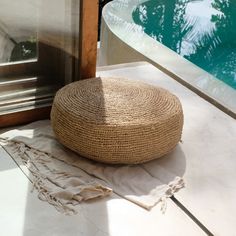 a large round pillow sitting on top of a white floor next to a swimming pool