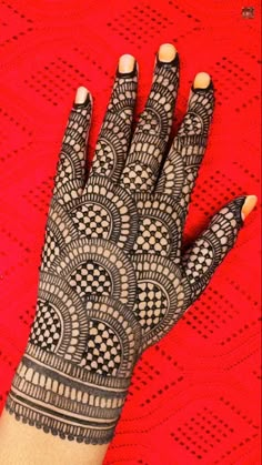 a woman's hand with hennap on top of red tablecloths