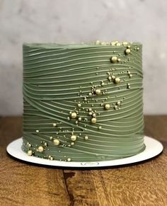 a green cake sitting on top of a wooden table