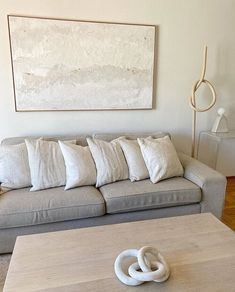 a living room with a couch, coffee table and art on the wall above it