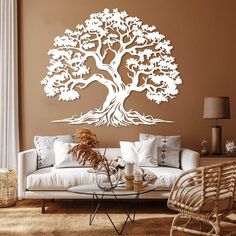 a living room filled with furniture and a large tree wall decal on the wall