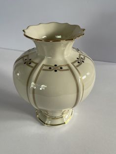 This beautiful Lenox Vanguard Collection vase is a vintage piece that will add a touch of elegance to any room. The ivory color and gold trim give it a classic look, while the raised relief and hand-painted features make it a unique piece. Measuring at 7 inches in length, this vase is the perfect size for displaying flowers or as a standalone decorative item. Made in the United States, this original piece is made of high-quality porcelain and is easy to clean with a damp cloth. It is a one-of-a- Ivory Color, Gold Trim, Classic Looks, Thoughtful Gifts, Unique Pieces, Decorative Items, Porcelain, Vase, Trim