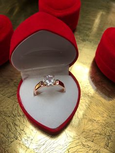 an engagement ring in a red velvet box