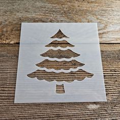 a cut out christmas tree sitting on top of a wooden table