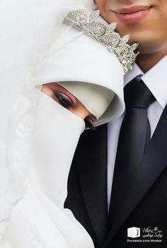 a man in a suit and tie with a tiara on his head wearing a white dress