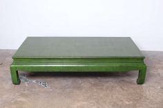 a green coffee table sitting on top of a cement floor