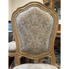 the back of a chair is upholstered with an intricately decorated fabric on it