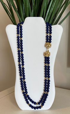 Kenneth Jay Lane's royal blue faux lapis beaded double strand necklace with double gold plated ram's heads encrusted with clear rhinestones and green rhinestone eyes. This was by designer Kenneth Jay Lane for Avon and in excellent condition. Please see pictures and video for description. Signed K.J.L. for Avon at clasp. Please visit my shop for more vintage jewelry: https://vintagetimejewelry.etsy.com/ Blue Beads Necklace, Ram Head, Rhinestone Eyes, Blue Beaded Necklace, Double Strand Necklace, Celebrity Design, Kenneth Jay Lane, Jewelry Business, Strand Necklace