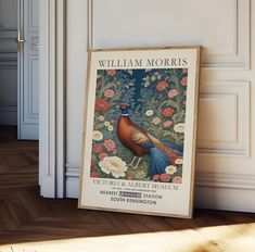 a poster on the floor in front of a white wall with flowers and a bird