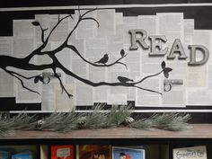 there is a sign that reads read on the side of a book shelf with pine branches