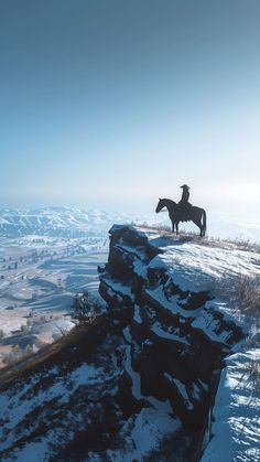 a lone horse standing on top of a snow covered mountain