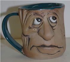 a ceramic mug with a face painted on it