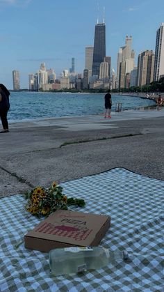 a table with a box and flowers on it in front of a cityscape