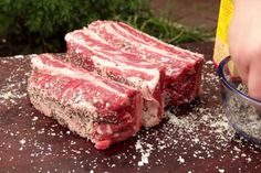 raw meat being cut into pieces on a table