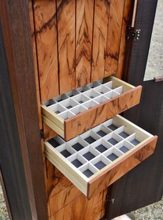 two drawers are open on the side of a wooden door with glass inserts in them