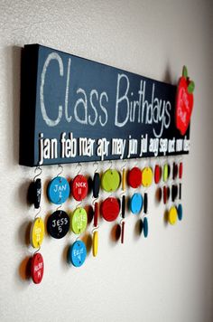 a sign that says class birthdays hanging on a wall with magnets attached to it