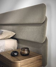 a bed with a headboard made out of wood and pillows on top of it