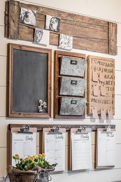 a wall with several calendars hanging on it's sides and flowers in a basket