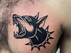 a man's chest with a black and white tattoo of a growling dog on it