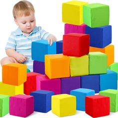 a toddler playing with colorful blocks on the white floor and in front of it