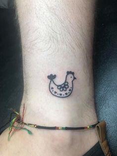 a small tattoo on the ankle of a person's foot, with a chicken