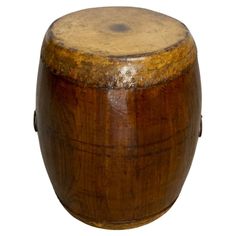 an old wooden barrel with some rust on the top and bottom, sitting in front of a white background