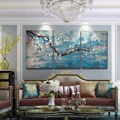 a living room with couches, tables and paintings on the wall in it's center