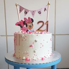 a minnie mouse birthday cake with pink and white sprinkles on the top