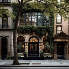 an apartment building with many windows and plants growing on the side of it's doors