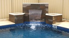 a water feature in a swimming pool surrounded by concrete blocks